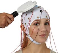 P_BrainCap_TMS worn by a participant with a TMS coil positioned over the scalp for simultaneous EEG and TMS recording