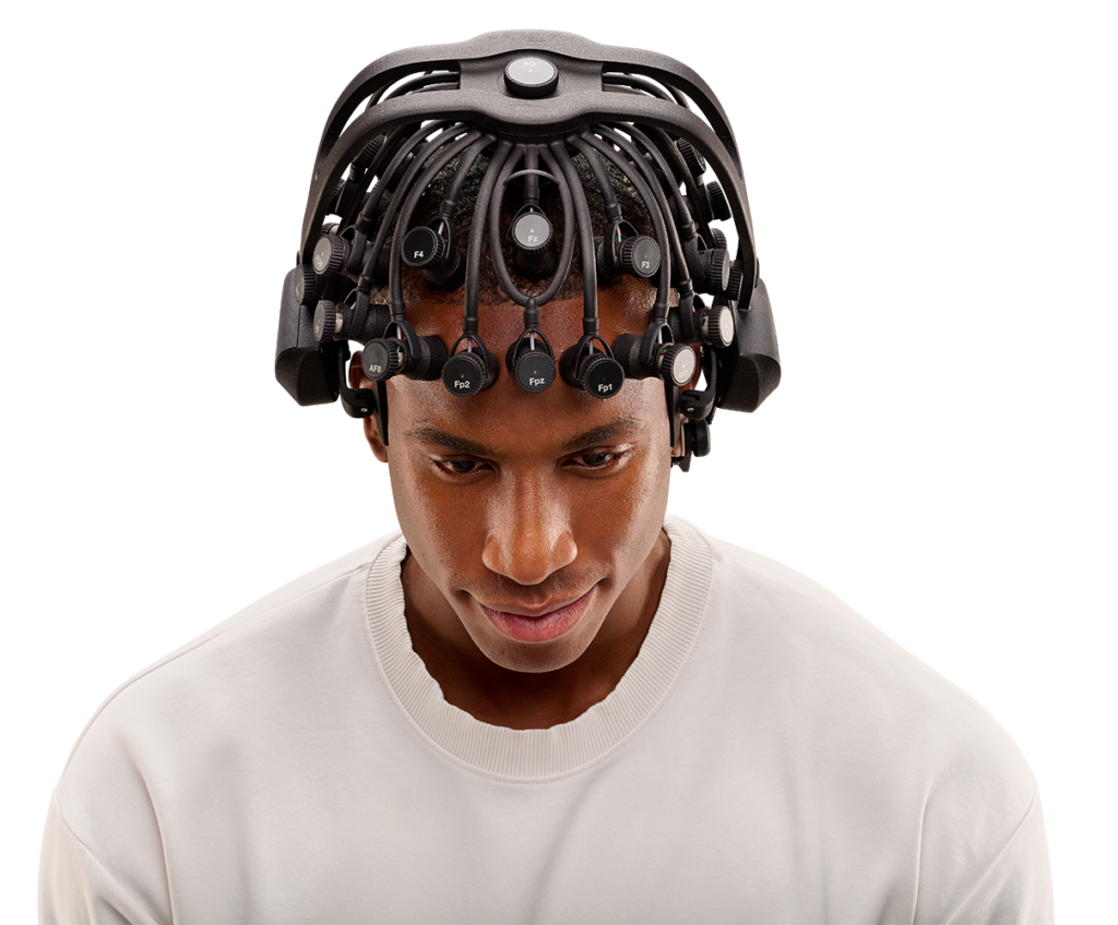 A Quick-32r headset sits on a man's head while he tilts his head forward slighly showing the top of the headset.