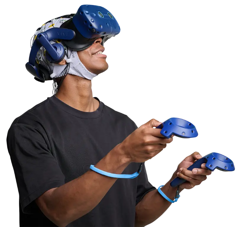 Participant wearing EEG cap and using VR headset and controllers during immersive neurotechnology experiment