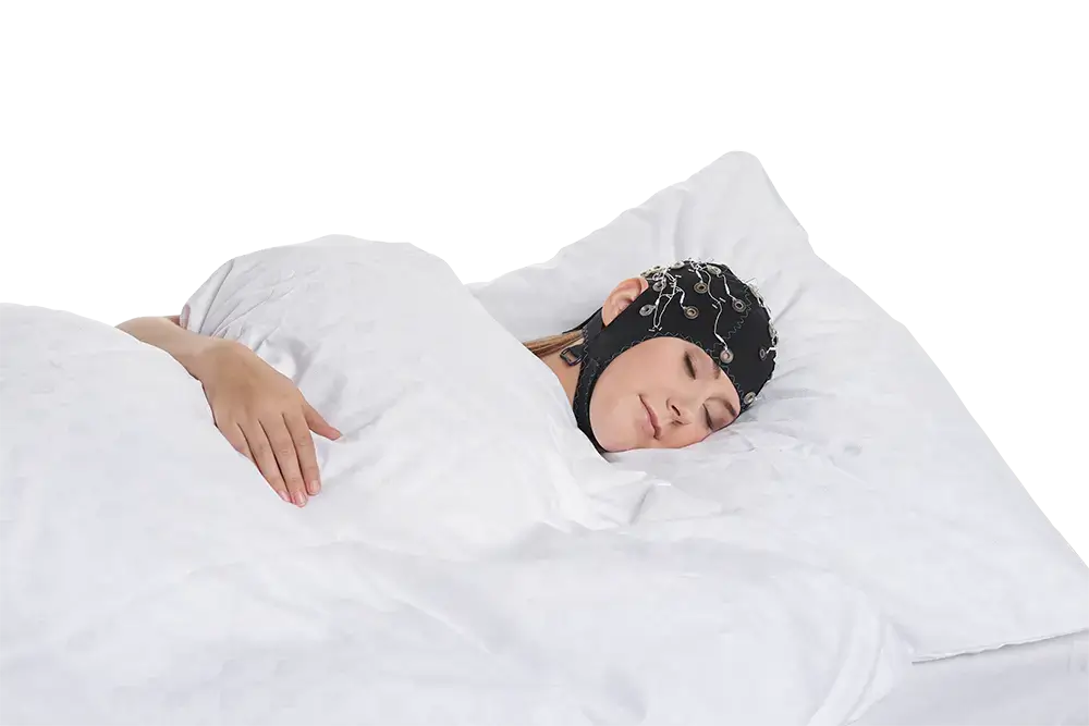 Person wearing EEG cap while lying in bed, demonstrating a sleep study setup