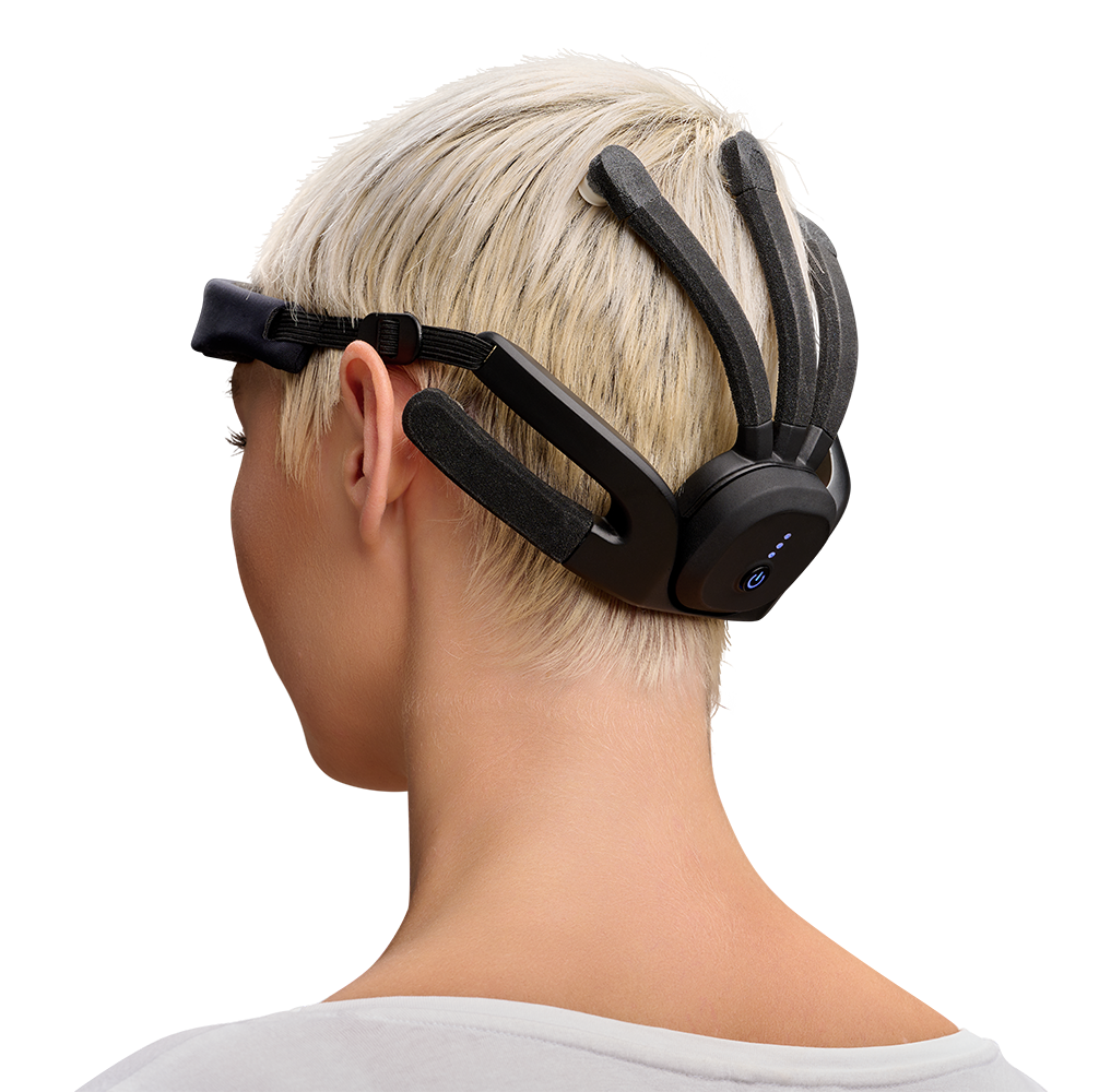 A blond female model is facing away from us while wearing the Mindtooth Touch System on her head.