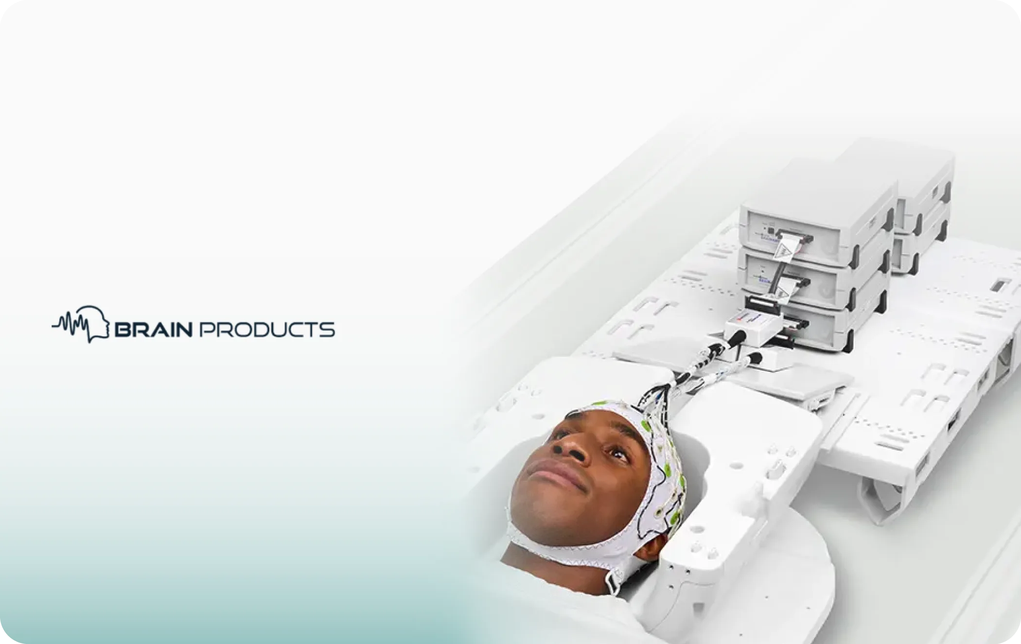 Participant wearing an MR-compatible Brain Products EEG cap on an MRI scanner bed
